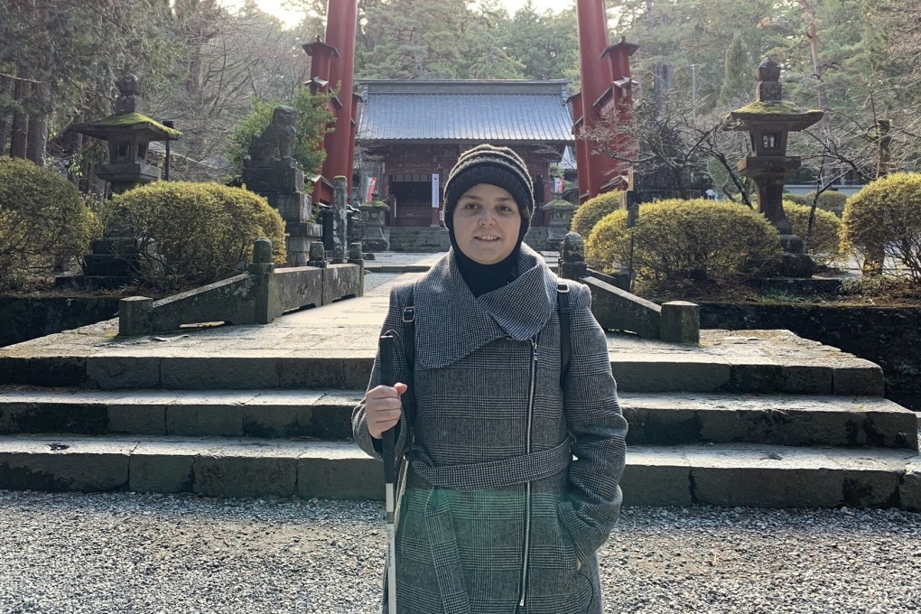 Mona Minkara stands in front of a tall red gate at the Fujiyoshida Sengen Shrine in Japan. The bioengineering professor films her travels on YouTube to show how the visually impaired can journey on their own using public transport. Photo: courtesy of Mona Minkara