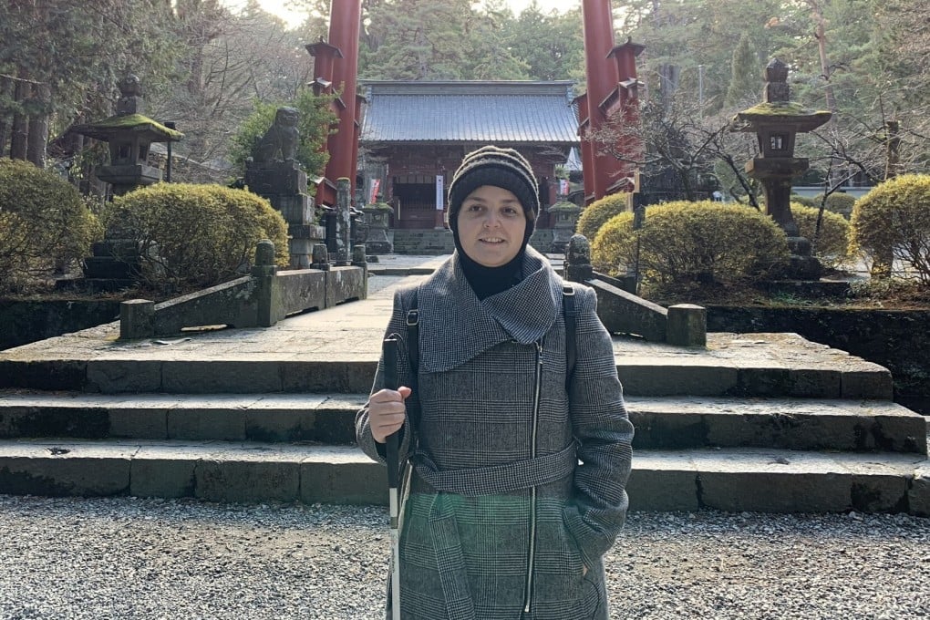Mona Minkara stands in front of a tall red gate at the Fujiyoshida Sengen Shrine in Japan. The bioengineering professor films her travels on YouTube to show how the visually impaired can journey on their own using public transport. Photo: courtesy of Mona Minkara