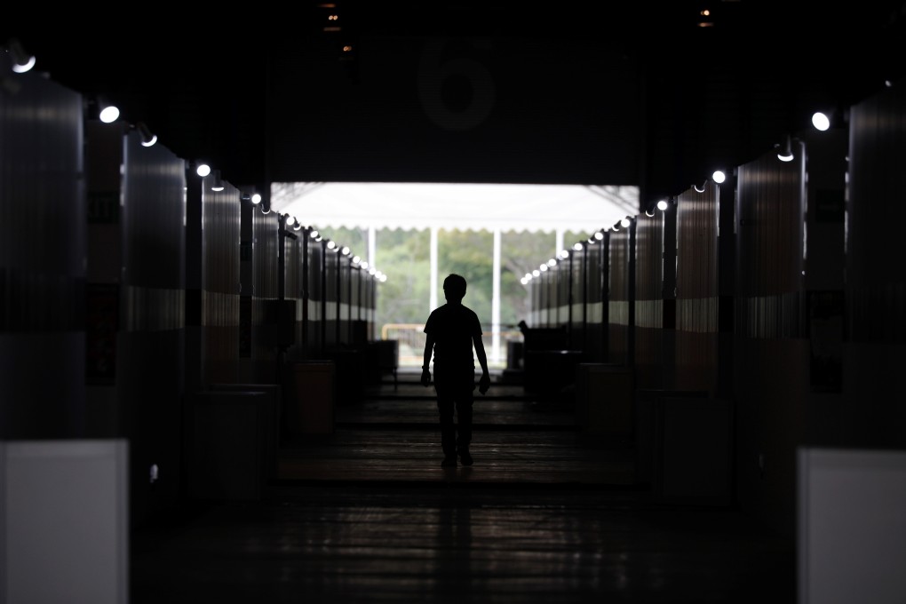 A man walks past partitioned rooms at Changi Exhibition Centre in Singapore, which has been repurposed into a community isolation facility for Covid-19 patients. Photo: Reuters