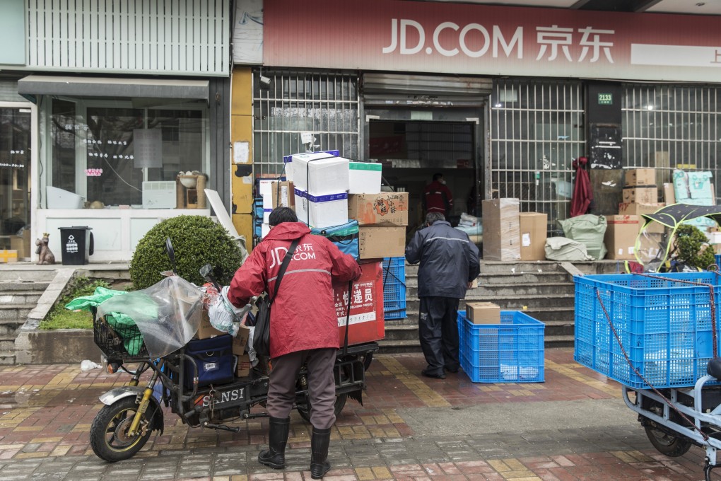 A delivery driver sorts parcels outside a JD.com warehouse in Shanghai on March 29, 2020. Photo: Bloomberg
