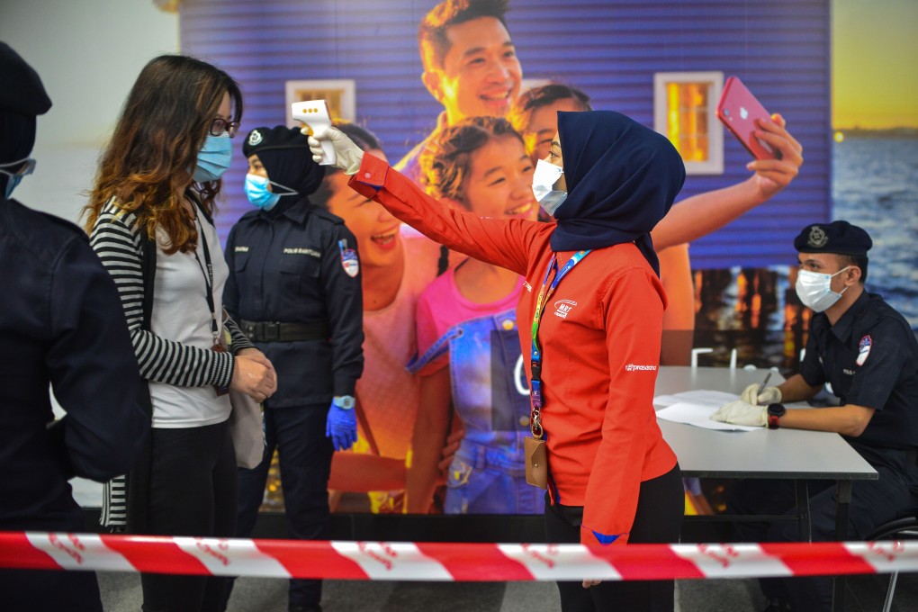 Staff on Kuala Lumpur’s light rail conduct temperature tests on passengers. Malaysia has been impacted by partial lockdown measures to curb the spread of coronavirus since March 18. Photo: Xinhua