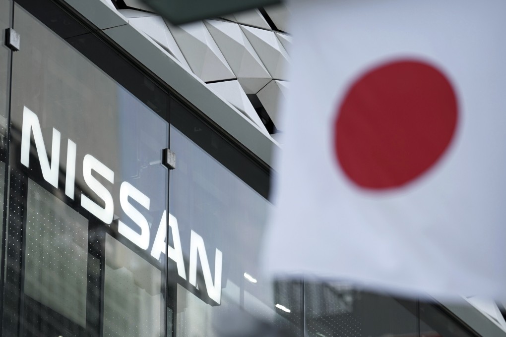 Nissan logo is seen near a Japanese flag at the carmaker's showroom in Tokyo. Nissan filed a civil suit in February seeking damages from its former Chairman Carlos Ghosn. Photo: AP