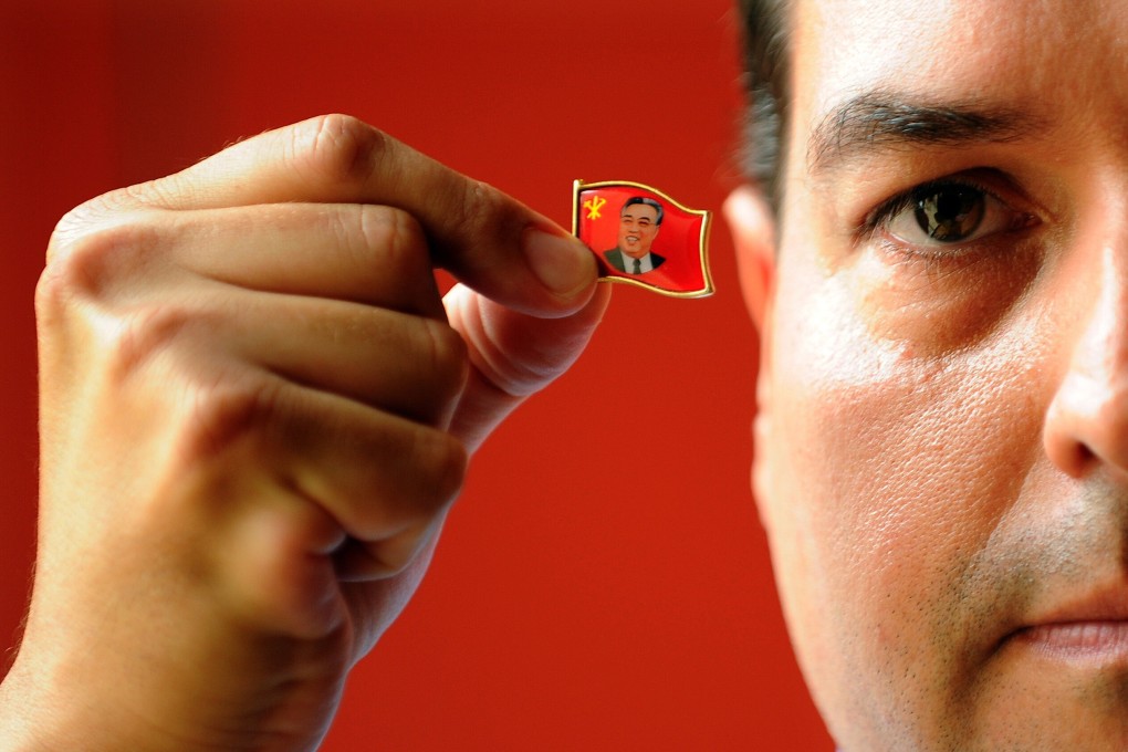 Alejandro Cao de Benós, a special delegate to North Korea’s Committee for Cultural Relations with Foreign Countries, holds a pin of the country’s first supreme leader, Kim Il-sung. Photo: AFP