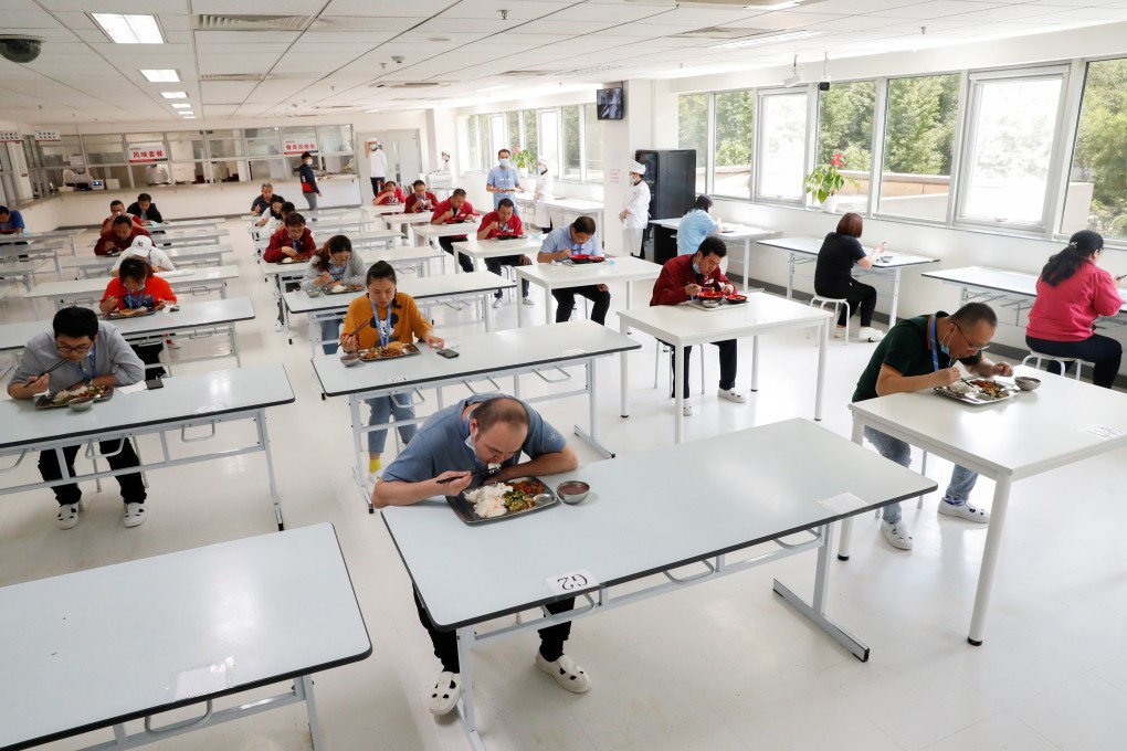 Employees observe social distancing during their lunch break at a factory in Beijing. Photo: Reuters