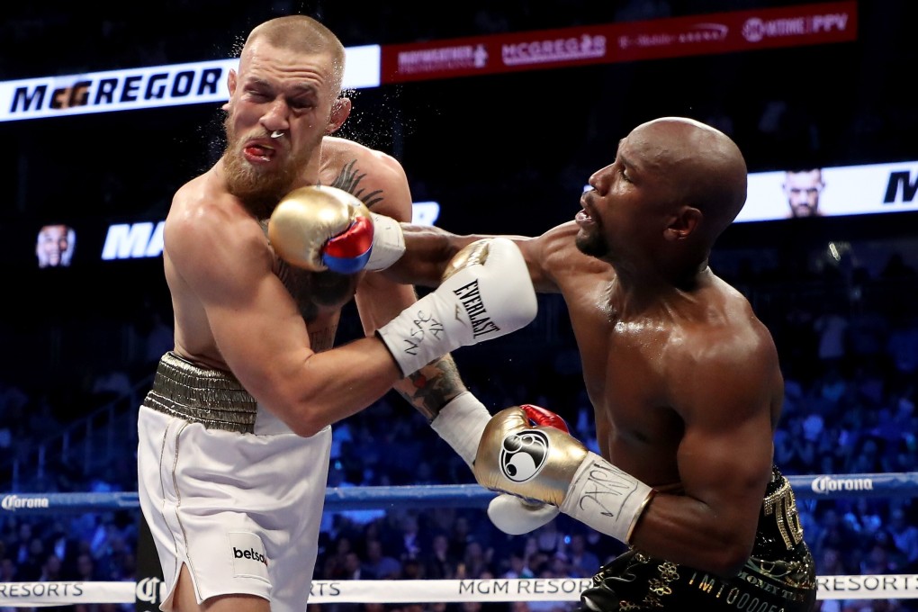 Floyd Mayweather throws a punch at Conor McGregor. Photo: AFP