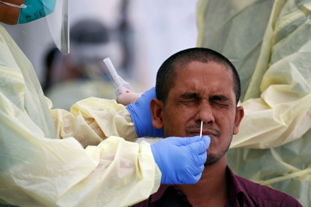 Medical workers perform a nose swab on a migrant worker at a dormitory in Singapore, amid an outbreak of Covid-19 among foreign workers in the city state. Photo: Reuters
