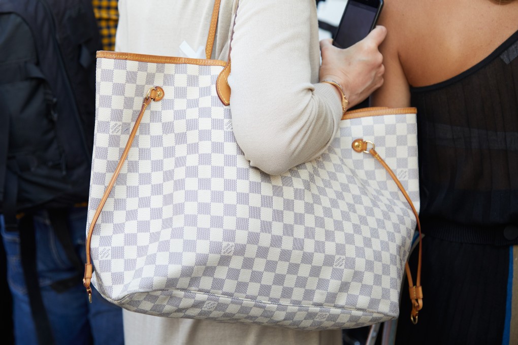A woman with a grey and white check Louis Vuitton bag attends a fashion show in Milan, Italy. Chanel and Louis Vuitton are raising prices to preserve their margins amid rising costs. Photo: Shutterstock