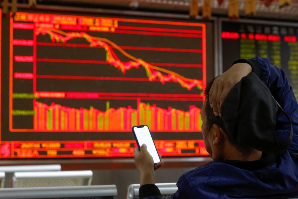 An investor sits in front of displays showing stock information at a brokerage office in Beijing. Photo: Reuters