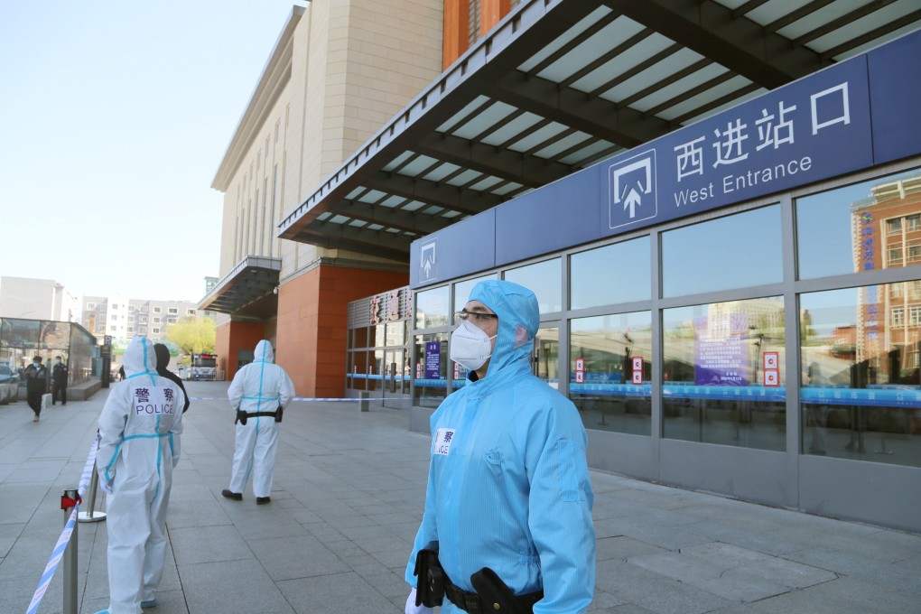 Police officers in protective suits stand outside a closed railway station in Jilin city. Photo: Reuters