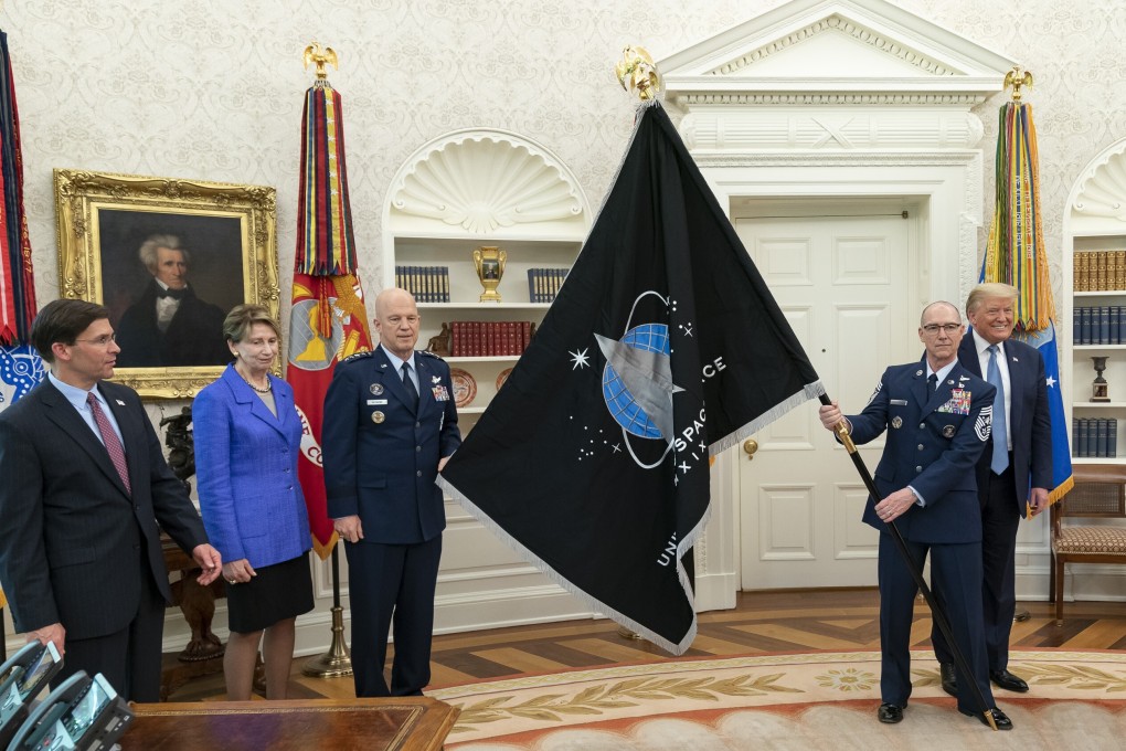 US Space Force CSO GEN Jay Raymond and US Space Force Senior Enlisted Advisor CMSgt Roger Towberman present US President Donald Trump with the US Space Force Flag. Photo: dpa