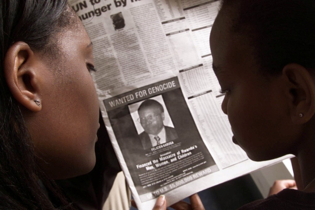 People in Nairobi look at a page of a newspaper in June 12, 2002 carrying the photograph of fugitive Felicien Kabuga. File photo: Reuters
