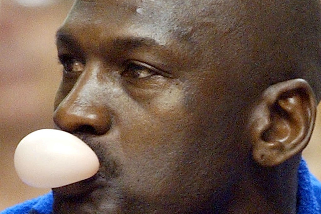 Michael Jordan amuses himself while sitting on the bench during an NBA game for the Washington Wizards. Photo: Reuters