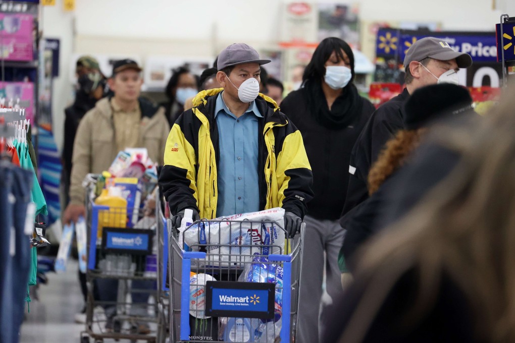 People wearing masks and gloves queue at a Walmart checkout in Uniondale, New York. By one estimate, the trade war has cost the average family in the US about US$460 a year. Photo: AFP