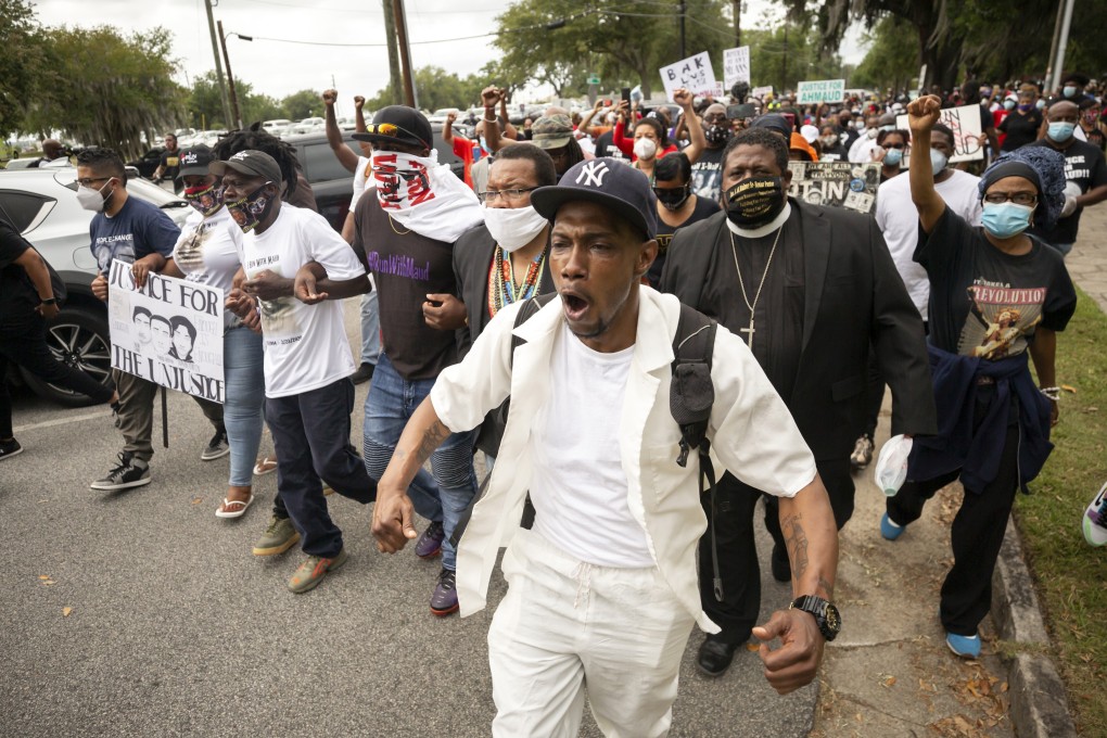 A group of people march from the Glynn County Courthouse in downtown to a police station after a rally to protest the shooting of Ahmaud Arbery. Photo: AP