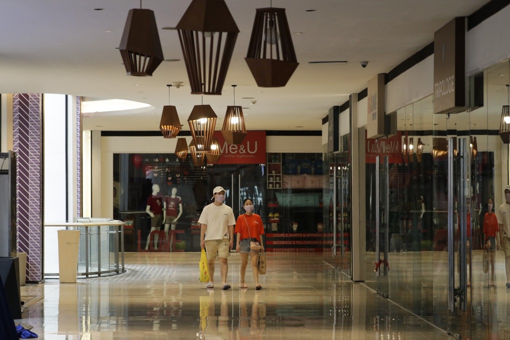 Shoppers wear masks as they walk through an almost empty shopping centre in Manila on May 16, 2020. Photo: AP