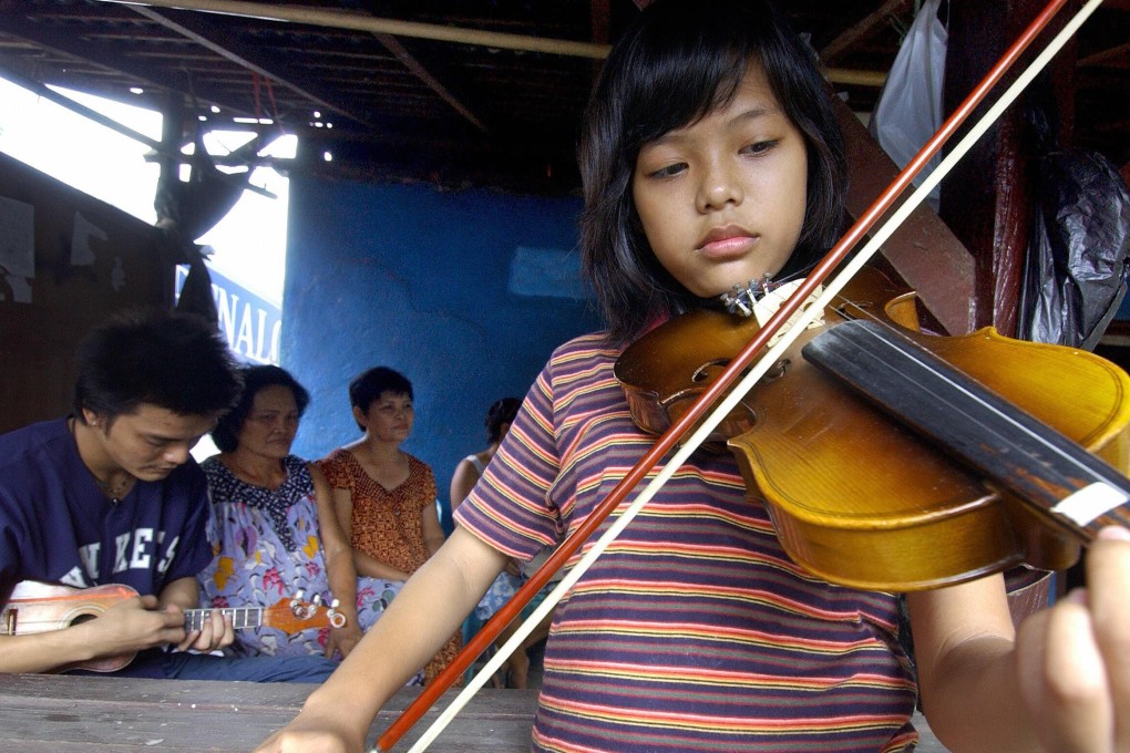 Milton Augustino Michiels and his niece Citra Augusta Margriette (front) play kroncong music at home in Kampung Tugu, Jakarta. A tour company that usually runs guided tours of the urban village has launched a virtual tour of it, and other places of interest in the Indonesian capital, amid the coronavirus pandemic that has halted international travel. Photo: Bay Ismoyo/AFP/Getty Images