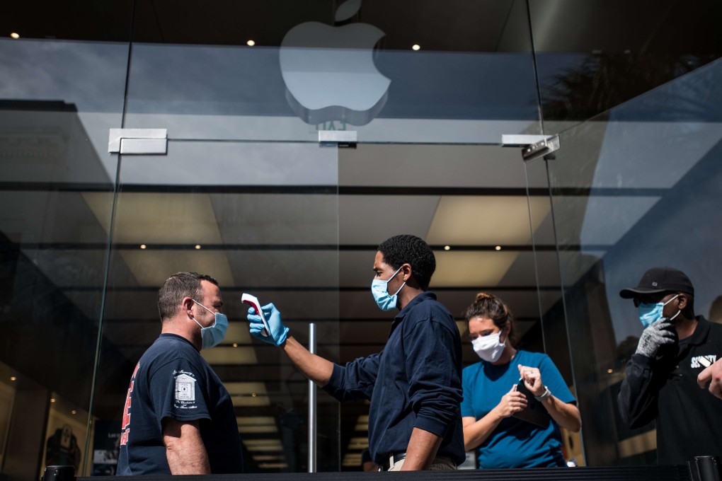 A security guard checks a customer’s temperature outside the Apple Store in Charleston, South Carolina, on May 13. Photo: Agence France-Presse