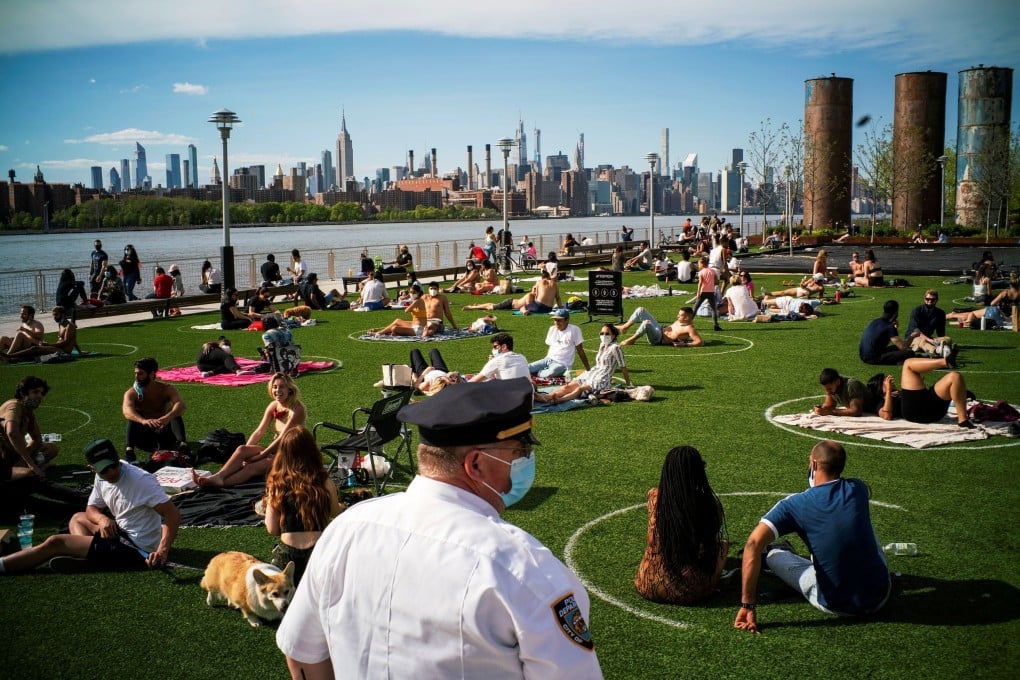 A New York police officer ensures people practice social distancing at Domino Park in Brooklyn, New York. Photo: Reuters