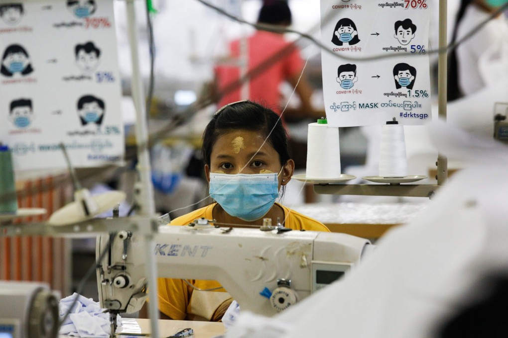 A worker wearing a face mask sews disposable surgical gowns for health workers at a garment factory in Yangon, Myanmar. Photo: AFP