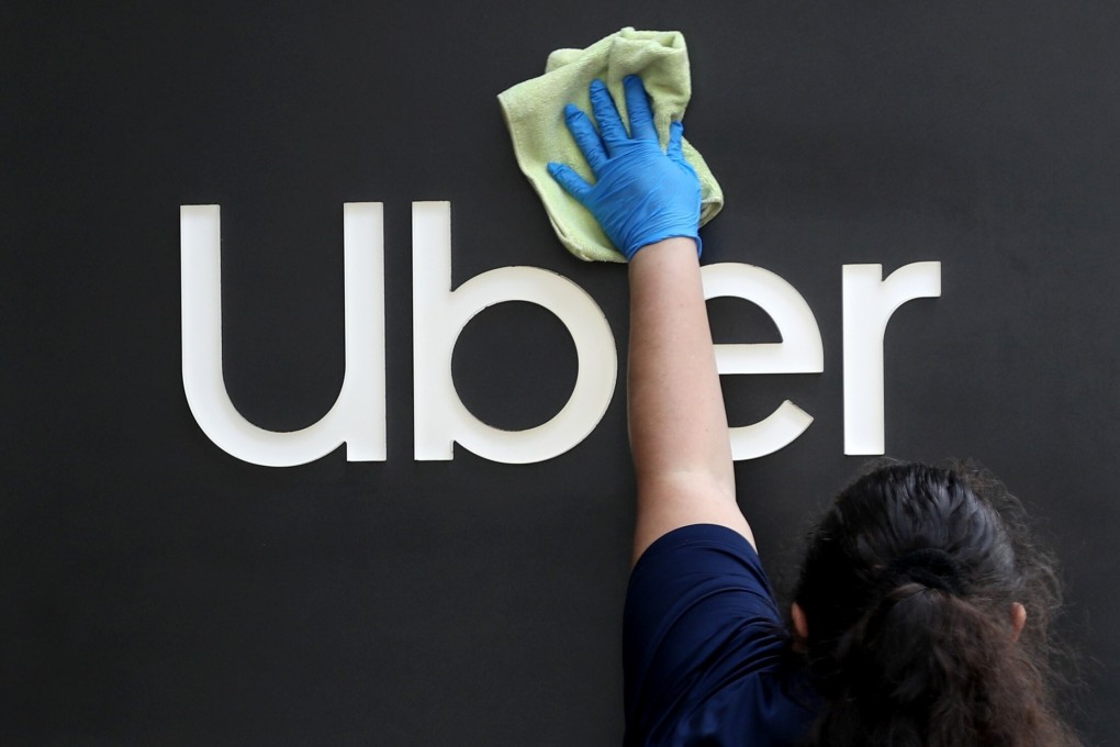 A worker cleans a sign in front of the Uber headquarters in San Francisco, California. Photo: AFP