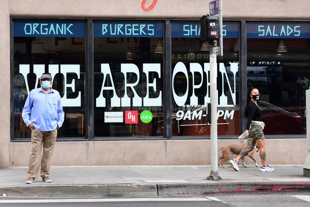 Pedestrians in front of a Los Angeles restaurant that is open for takeout only. California Governor Gavin Newsom announced guidelines for reopening that include self-distancing and stricter cleanliness procedures. Photo: AFP