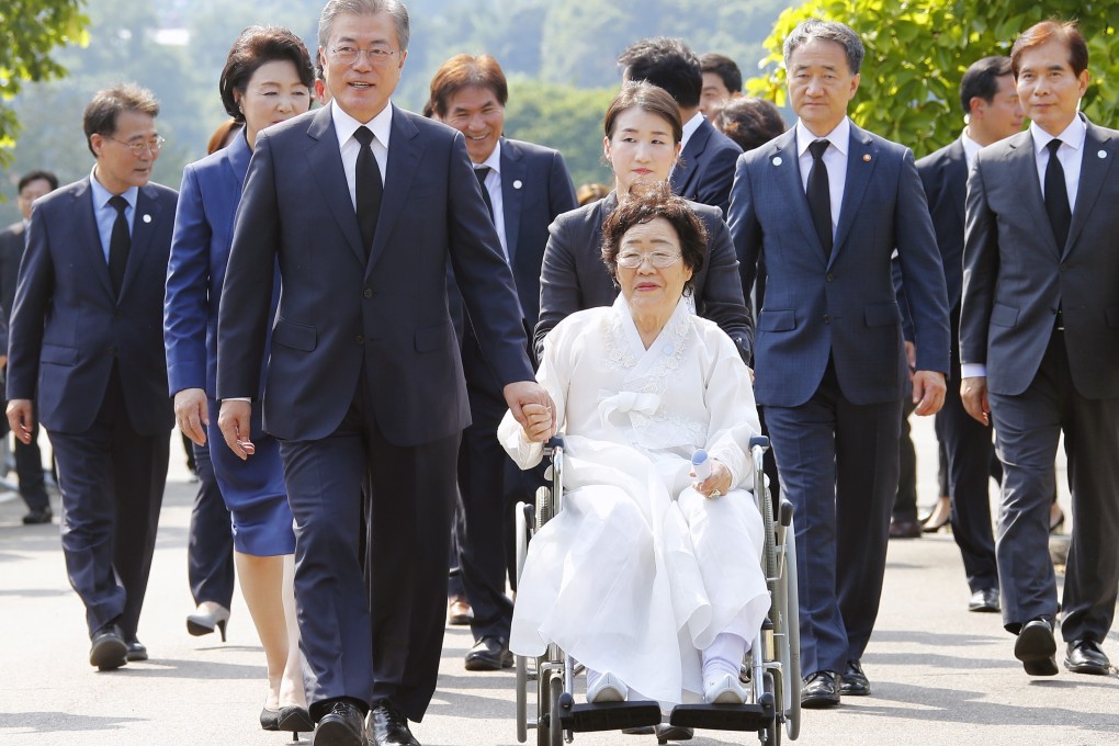 South Korean President Moon Jae-in holds the hand of Lee Yong-soo during a trip to a comfort women's cemetery in Cheonan, South Chungcheong Province, South Korea. Photo: EPA