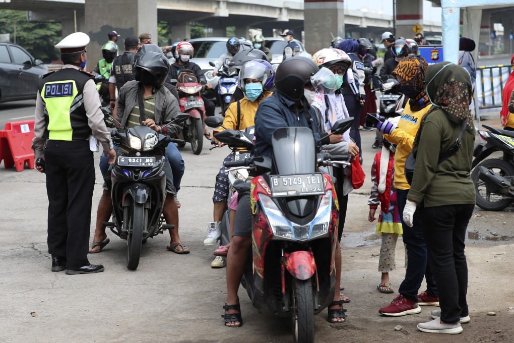 Indonesian police and government officers question motorists at a police checkpoint on the outskirts of Jakarta. Photo: AP