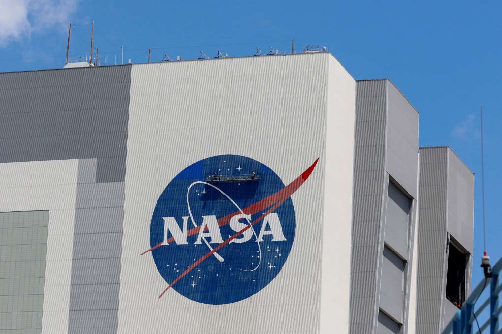 Workers pressure wash the logo of Nasa on the Vehicle Assembly Building. Photo: Reuters