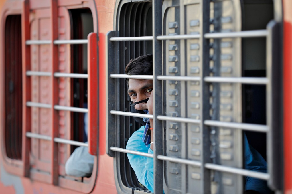 A migrant worker, who was stranded in the western state of Gujarat due to a coronavirus lockdown, looks out from a train that will take him home to Uttar Pradesh on May 5. Photo: Reuters