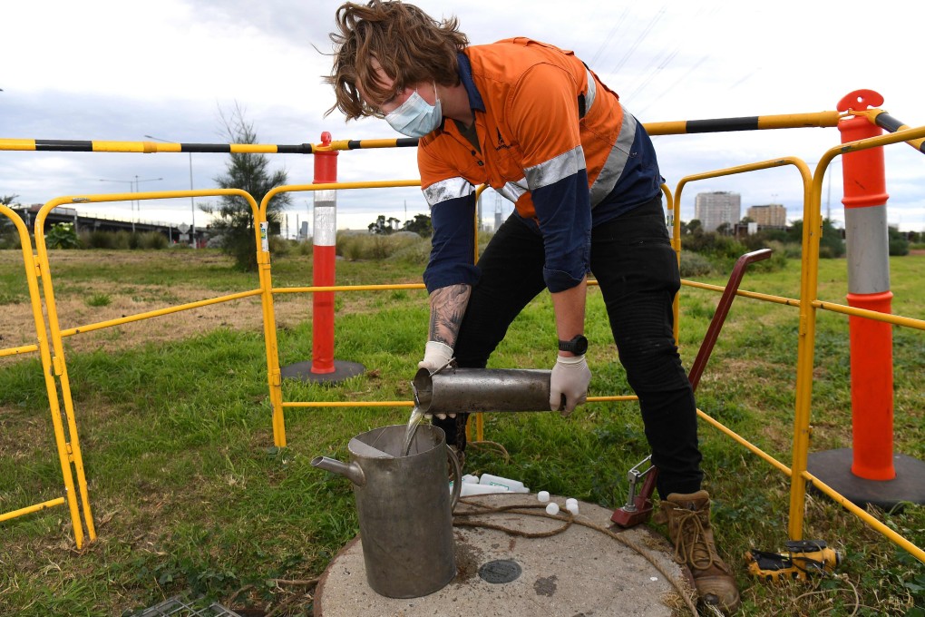 A hydrographer takes samples from a sewer in Melbourne. Photo: AFP