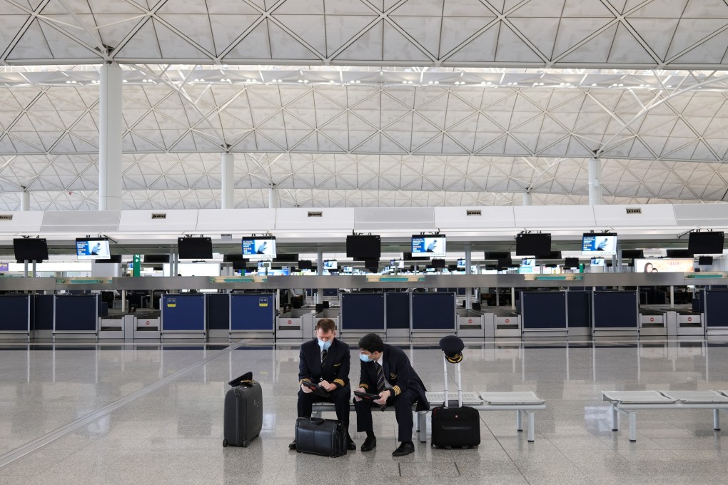 Two pilots are seated at a nearly deserted Hong Kong International Airport on May 7. A proposed “travel bubble” could allow relatively small numbers of people to travel among these territories without being quarantined. Photo: Reuters
