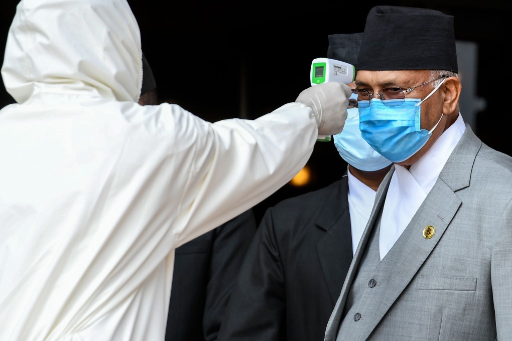 A health worker checks the temperature of Nepal’s Prime Minister K.P. Oli as he arrives at the parliament in Kathmandu. Photo: AFP