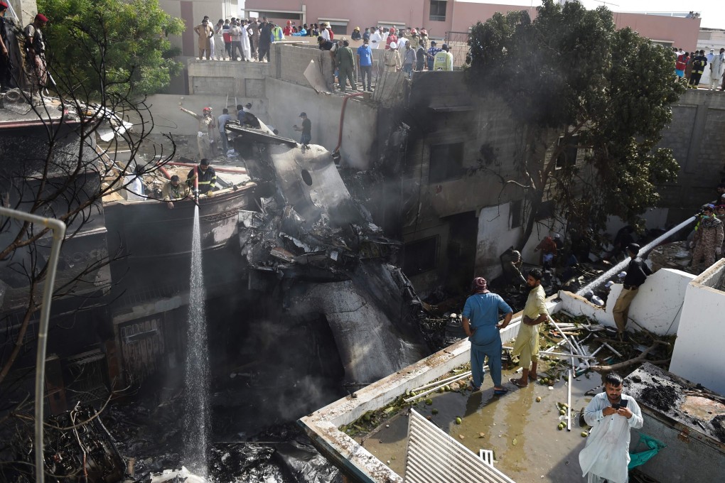 Firefighters at the scene of the crash in Karachi. Photo: AFP