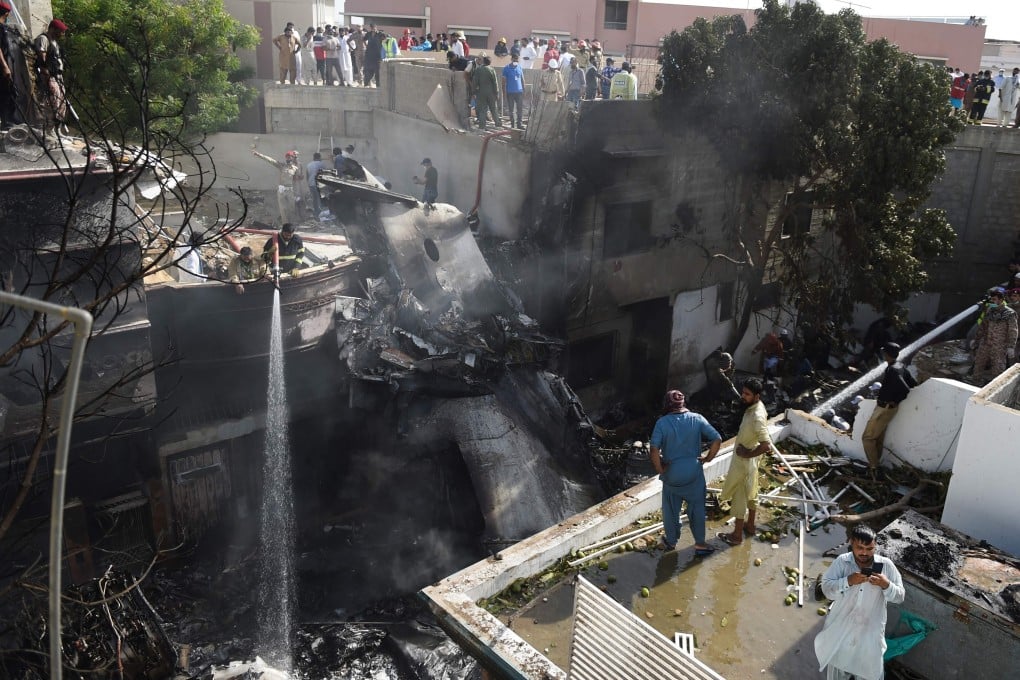 Firefighters at the scene of the crash in Karachi. Photo: AFP
