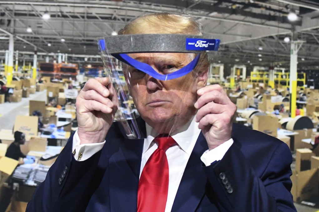 US President Donald Trump looks through a face shield at a factory in Michigan on May 21. Photo: Detroit News via AP