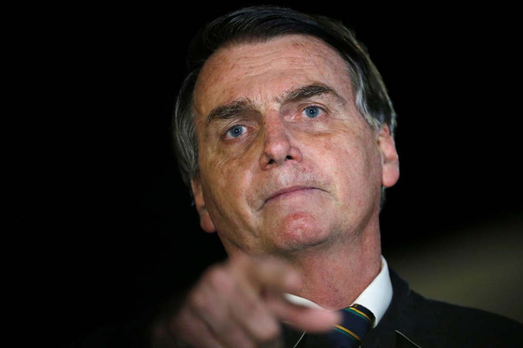 Brazil's President Jair Bolsonaro speaks with journalists as he arrives at Alvorada Palace in Brasilia. Photo: Reuters