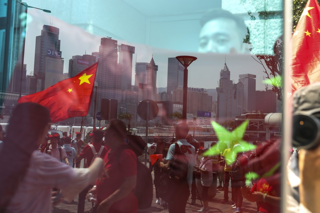 People wave the national flag to mark the 70th anniversary of the People’s Republic of China outside Bauhinia Square in Hong Kong. Photo: Nora Tam
