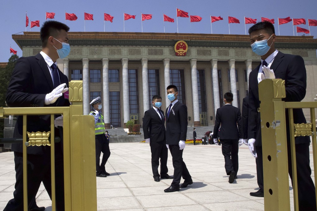 Chinese security officials stand guard outside the Great Hall of the People after the opening session of China's National People's Congress in Beijing on Friday. Photo: AP