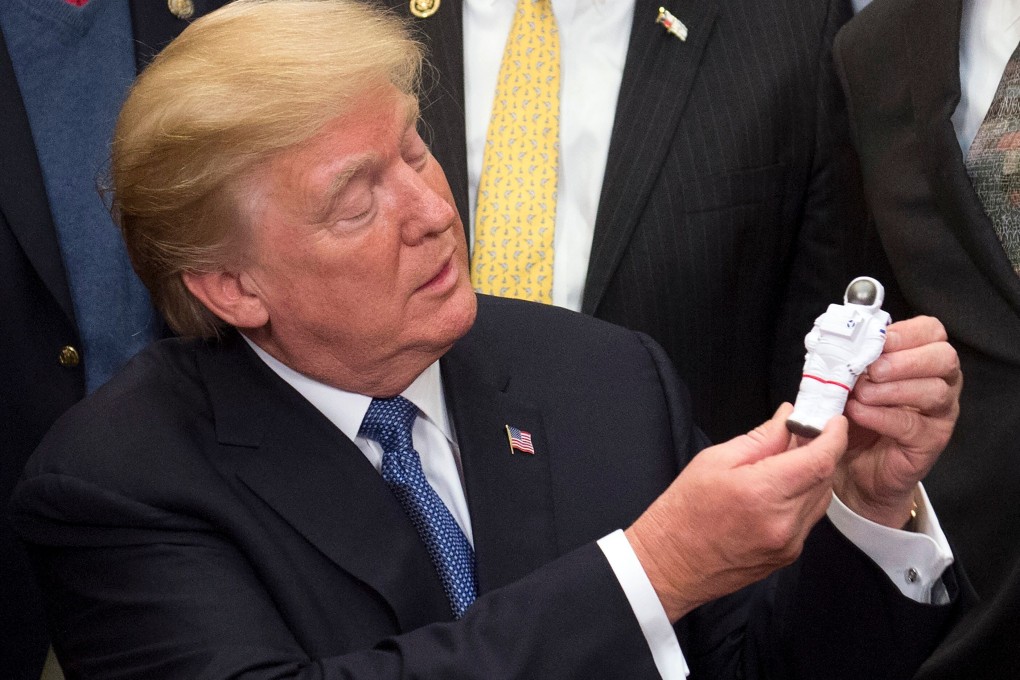 US President Donald Trump holds a toy astronaut after a signing ceremony for Space Policy Directive 1. Photo: AFP