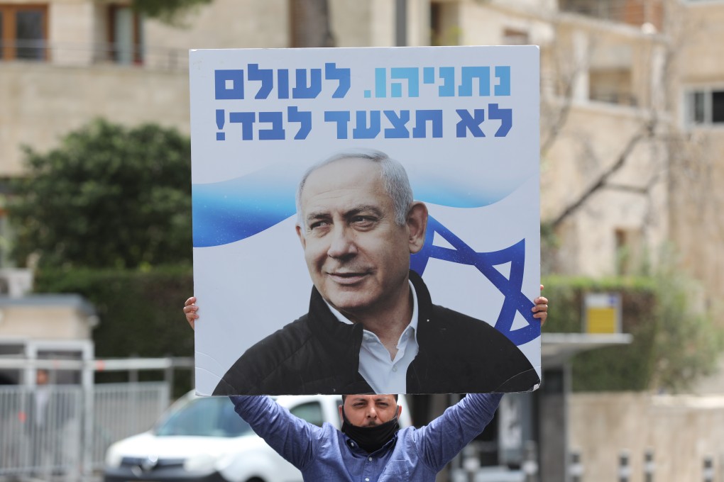 A supporter of Israeli Prime Minister Benjamin Netanyahu holds a sign that reads: ‘Netanyahu will never walk alone!’ Photo: EPA
