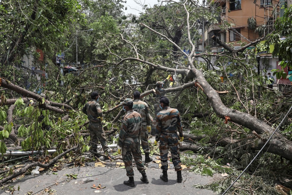 Indian soldiers cut trees to clear the roads in the aftermath of Cyclone Amphan. Photo: Reuters