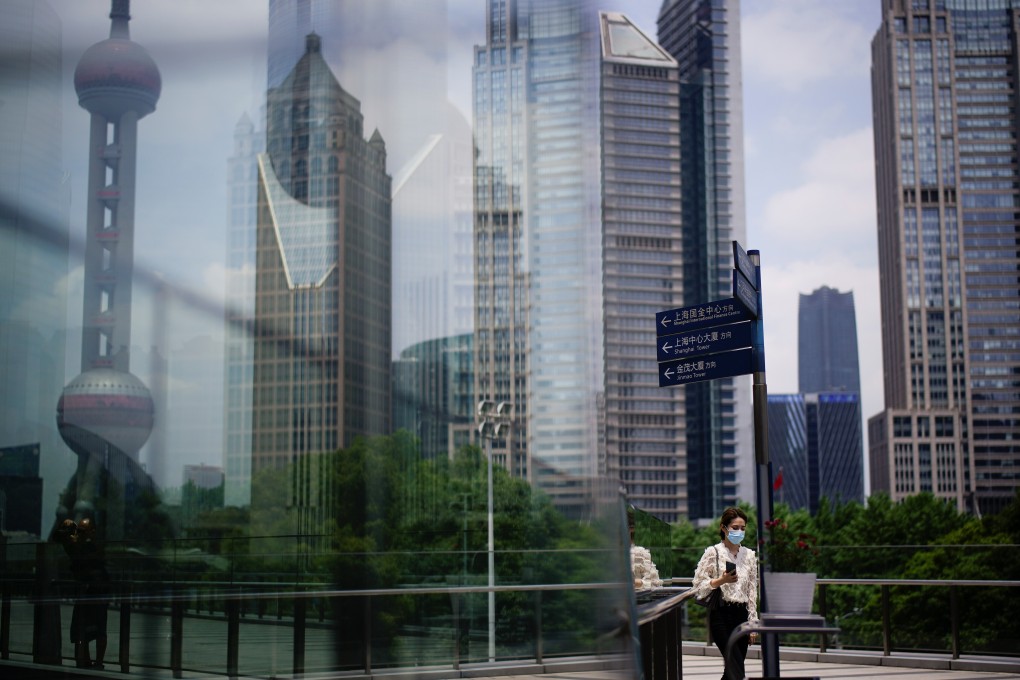 A woman walks through the Lujiazui financial district in Shanghai. In China, women make up 51 per cent of entry-level professionals, but only 22 per cent of middle management and 11 per cent of senior managers. Photo: Reuters