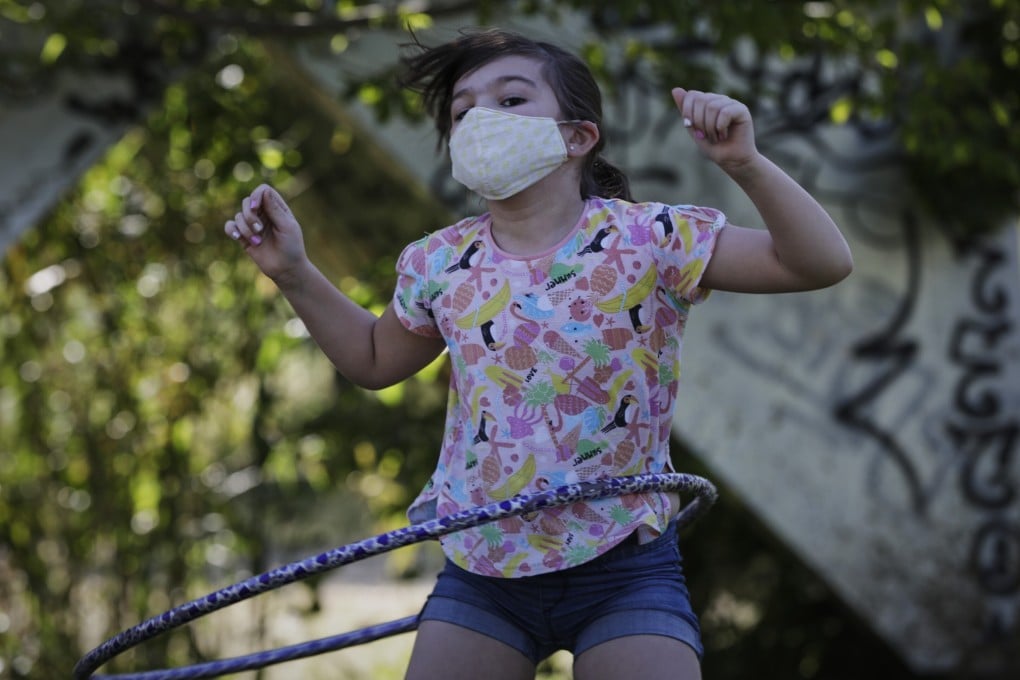 A nine-year-old girl wearing a protective mask plays hula hoop in Madrid, Spain. Experts give their tips on how to help an only child deal with isolation during the coronavirus pandemic.