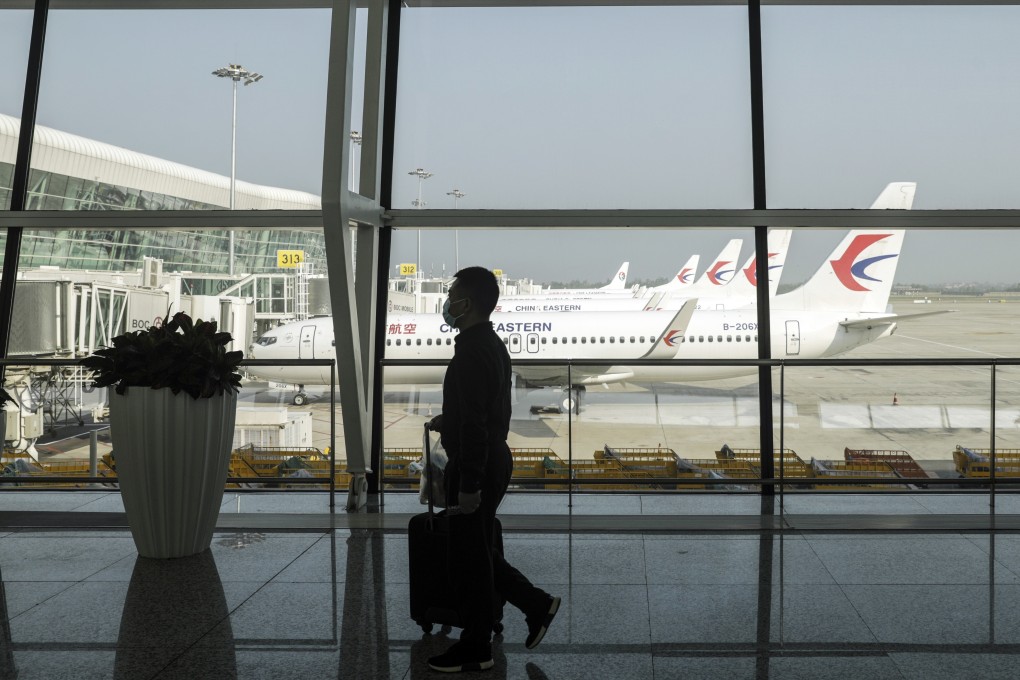 A passenger wearing a protective mask walks past China Eastern Airlines aircraft standing on the tarmac at the Wuhan Tianhe International Airport in Wuhan, China, on May 2. Photo: Bloomberg