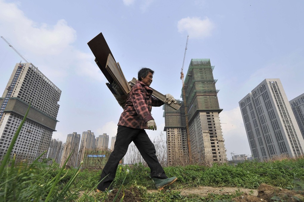 A labourer walks past residential and office buildings under construction in Hefei, Anhui province in April 2014. Many city governments are easing policies to spur the local property market only to be told by Beijing to undo them. Photo: Reuters
