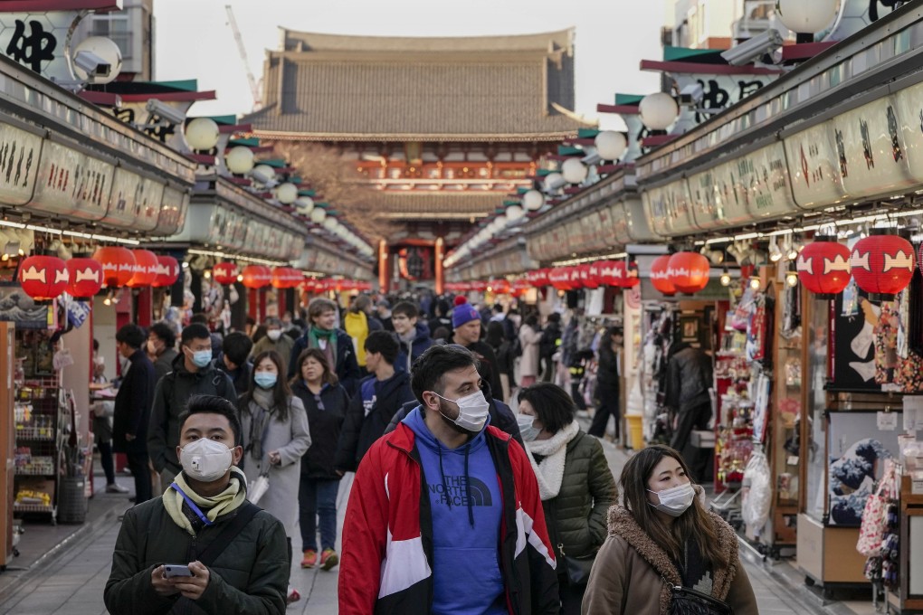Tourists wearing masks stroll through Tokyo’s Asakusa district, in March. Photo: EPA-EFE