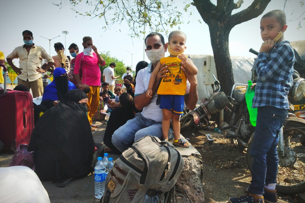 Migrant workers wait outside Mumbai's Bandra Terminus railway station. A handful of special trains are being run to take migrant workers back to their hometowns. Photo: Kunal Purohit