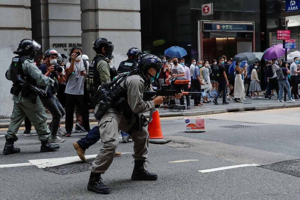 A riot police officer fires his weapon during a protest near the government headquarters, as a second reading of a controversial national anthem law gets under way in Hong Kong, with many in the city already on edge over a looming tailor-made national security law drafted by Beijing. Photo: Reuters