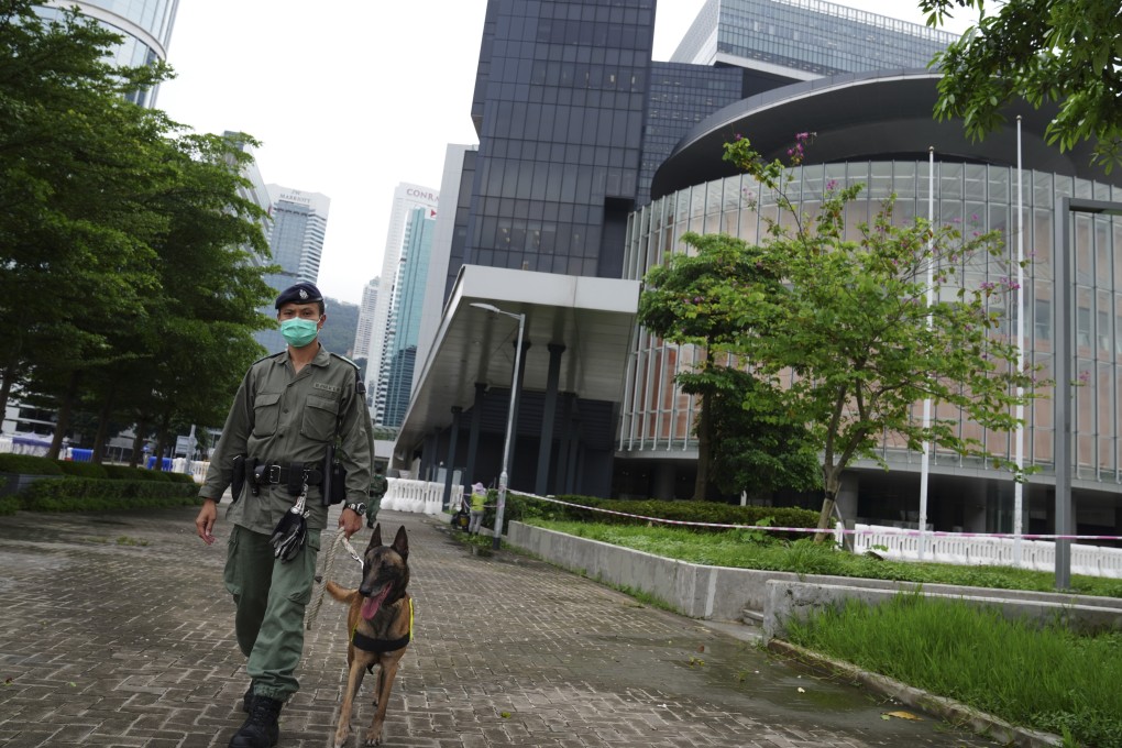 A police officer patrols with a dog outside Hong Kong’s Legislative Council building ahead of a planned Wednesday protest of a controversial national anthem law. Photo: Sam Tsang