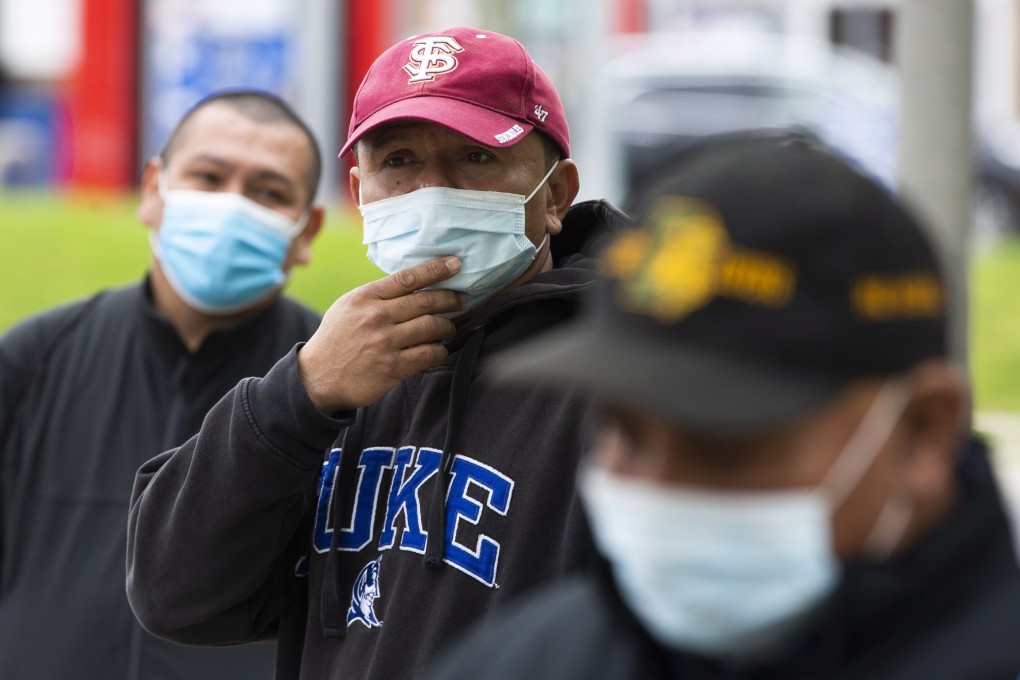 Day labourers wait in hope of being hired at a park in Shirlington, Virginia, on May 8. Photo: EPA-EFE